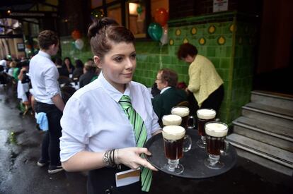 Una camarera lleva una bandeja con cafés irlandeses en el pub Mercantile, el pub irlandés de mayor tradición en The Rocks, Sídney (Australia).