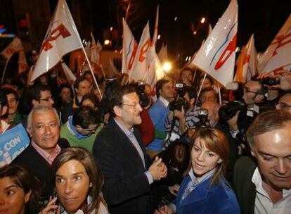 Rajoy, Dolores de Cospedal (derecha) y otros dirigentes del PP festejan con simpatizantes los resultados frente a la sede del partido.