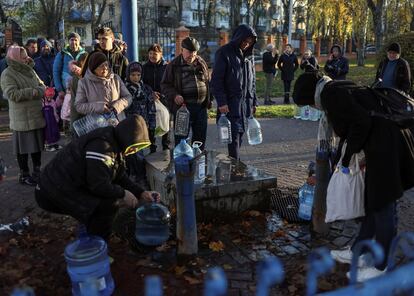 Vecinos de Kiev llenan garrafas con agua potable, tras una serie de bombardeos a las infraestructuras de la capital que les han dejado sin suministro, el pasado 30 de noviembre.