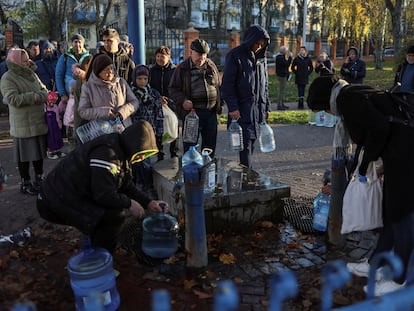 Vecinos de Kiev llenan garrafas con agua potable, tras una serie de bombardeos a las infraestructuras de la capital que les han dejado sin suministro, el pasado 30 de noviembre.