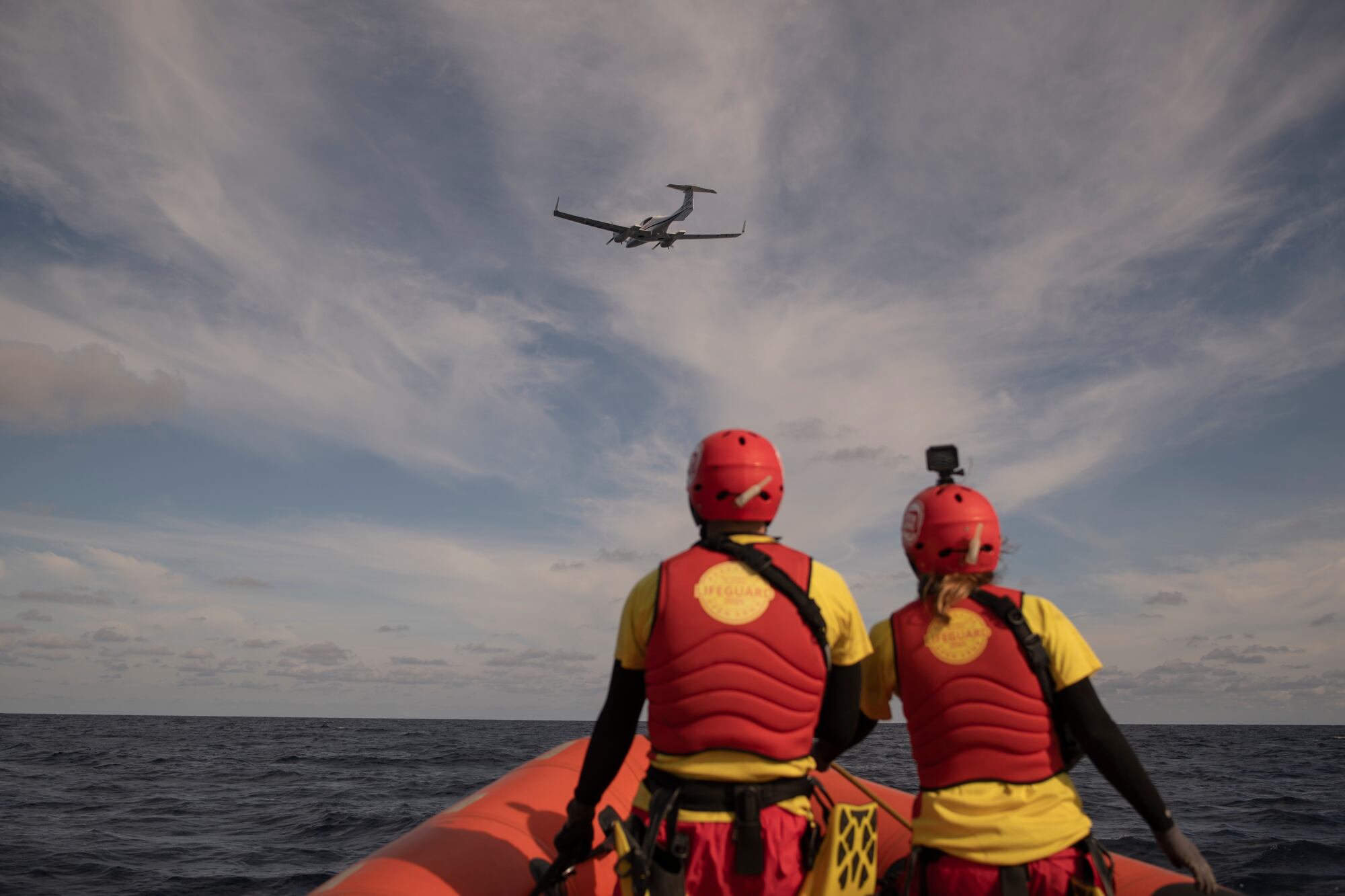 Los socorristas de la ONG Open Arms se desplazan en una lancha de rescate en el mar Mediterráneo para llegar al lugar donde se encuentra una embarcación con seis personas a bordo. Cuentan con la ayuda desde el aire del avión de búsqueda de la ONG francesa Pilotes Volontaires, que sobrevuela el área en la Zona SAR frente a la costa de Libia, el miércoles 3 de enero de 2024.  