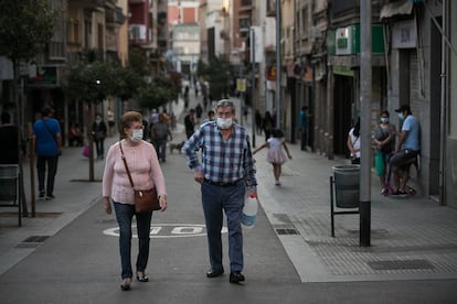 Dos personas caminan por el barrio de La Torrassa, en L'Hospitalet de Llobregat, Barcelona, el punto de mayor densidad de población de Europa, según un estudio.