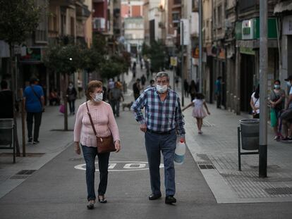 Dos personas caminan por el barrio de La Torrassa, en L'Hospitalet de Llobregat, Barcelona, el punto de mayor densidad de población de Europa, según un estudio.