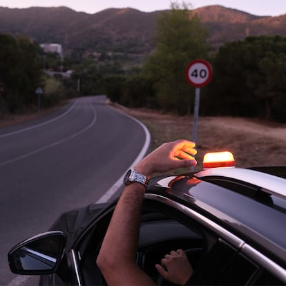 Una persona colocando la Baliza V16 en el techo de su coche.
