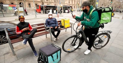 Repartidores de Glovo, Deliveroo y Uber Eats esperando algún servicio en Barcelona.