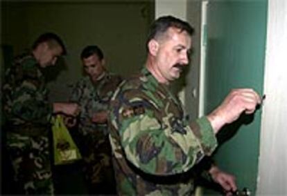 Un soldado croata de Bosnia sella una puerta en un barracón militar, ayer cerca de Mostar.