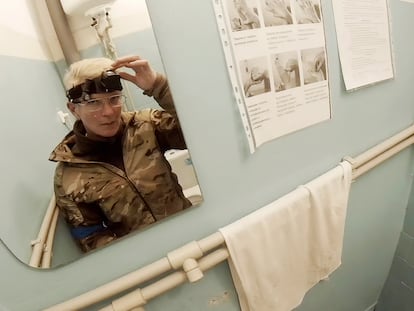 Yuliia Paievska, known as Taira, looks in the mirror and turns off her camera in Mariupol, Ukraine on Feb. 27, 2022. Using a body camera, she recorded her team's frantic efforts to bring people back from the brink of death. (Yuliia Paievska via AP)
