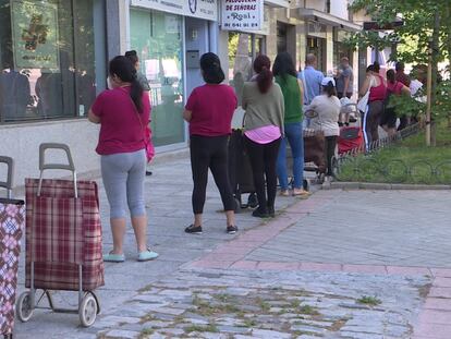 Cola de personas esperando a recibir alimentos y productos de primera necesidad en Madrid.