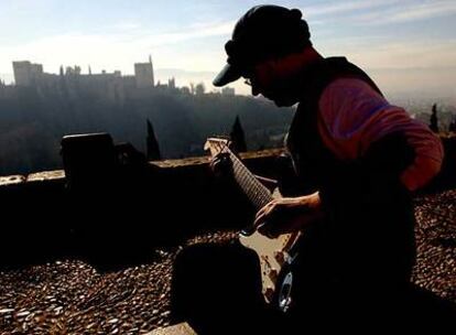 Ángel toca la guitarra en el mirador de San Nicolás, frente a la Alhambra de Granda.