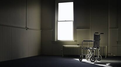 En la imagen, una silla de ruedas en una habitación vacía.
