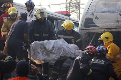 Bomberos mueven el cadáver de una persona tras la explosión de un camión cargada de gas en las proximidades de México DF.