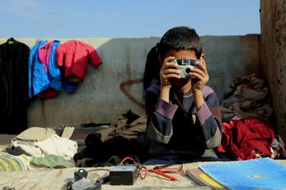 Un niño kurdo mira a través del visor de una cámara el 21 de enero de 2017 en un mercadillo popular en Qamishli (Siria).