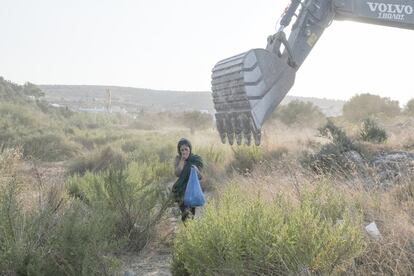 Una mujer cruza la obra en la que se construirán las carpas del nuevo campamento Kara Tepe. La construcción de este campamento en un tiempo récord deja grandes dudas sobre la seguridad y calidad de vida en este tipo de alojamientos.