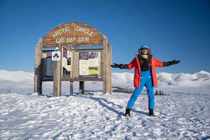 Mariel Galán posa junto al letrero de madera que indica que estás pisando el Círculo Ártico.