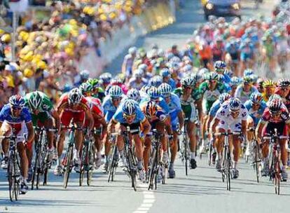 Mark Cavendish, en el centro del pelotón, de azul, esprinta para ganar la etapa de ayer. Tras él, de naranja, Óscar Freire, que quedó segundo.