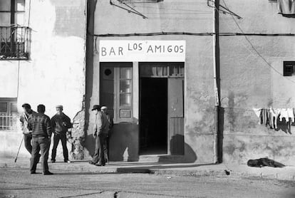 Varios hombres y un perro durmiendo cerca de la lavandería, fuera del bar Los Amigos, en Peñuelas de San Blas.