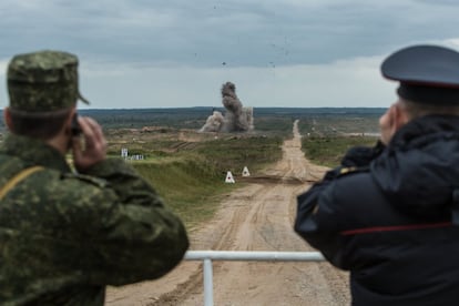 Un soldado bielorruso (izda.) y un policía del Ministerio del Interior bielorruso observan las maniobras que se desarrollan en la base de Asipovichy (Bielorrusia), el 18 de septiembre.