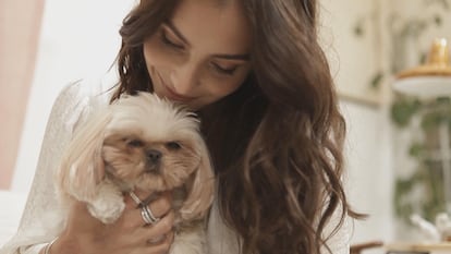 Andrea, con su perrita Canela, lleva el anillo Tres bandas cadena de serpiente en pavé y el anillo en plata de ley Barra Brillante. Ambos, de Pandora.