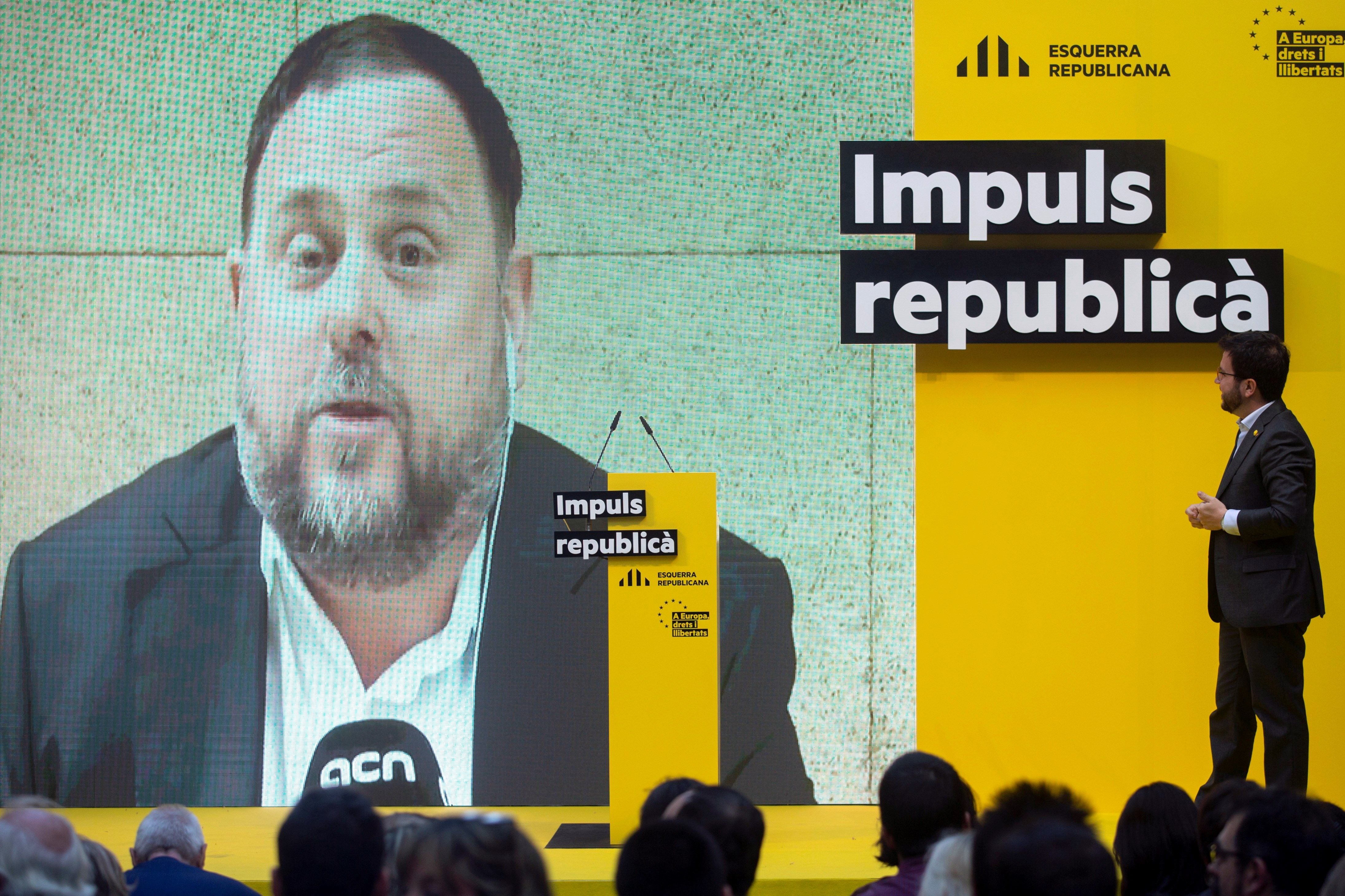 El vicepresidente del 'Govern', Pere Aragonès, escucha una intervención en vídeo del 'exvicepresident' Oriol Junqueras durante un acto electoral celebrado en Barcelona.
