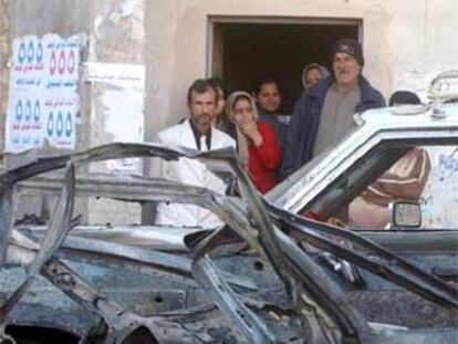 Unos iraquíes miran el coche destrozado de un suicida ayer en Bagdad.