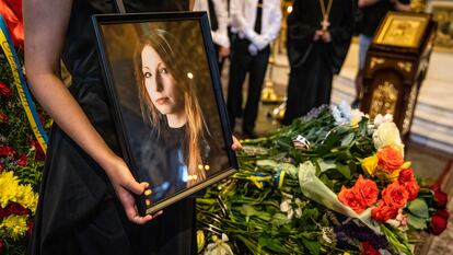 Una mujer sostiene una imagen de Victoria Amelina, durante el funeral de la escritora.
