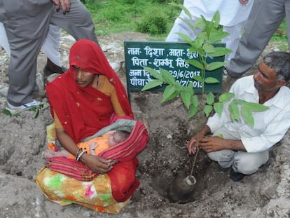 Pura y su marido Shubhum Singh plantan un árbol en honor al nacimiento de su hija Disha, en Piplantri (India), en junio de 2013.