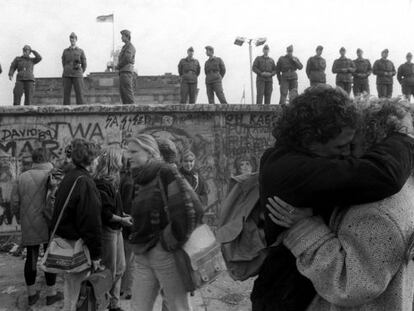 J&oacute;venes bes&aacute;ndose ante el Muro de Berl&iacute;n 