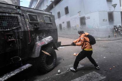 Un manifestante golpea un vehículo de la policía durante la protesta en Quito (Ecuador).