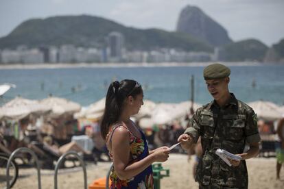 Soldado reparte panfletos informativos sobre o Zika em Copacabana.