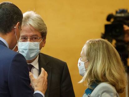 De espaldas, el presidente del Gobierno, Pedro Sánchez, junto a la vicepresidenta y ministra de Asuntos Económicos, Nadia Calviño conversan con el comisario Europeo de Economía, Paolo Gentiloni.