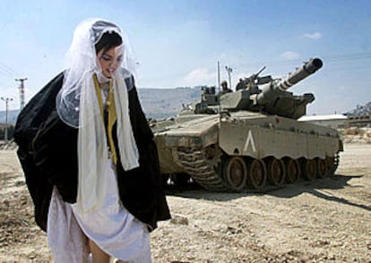 Una novia se dirige a su boda ante un tanque israelí, ayer en un campo de refugiados cercano a Nablús.