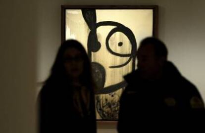 Dos visitantes frente a un cuadro de Miró.