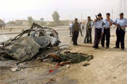 Policías iraquíes contemplan el cadáver de un civil muerto durante un ataque de la resistencia en Bagdad.