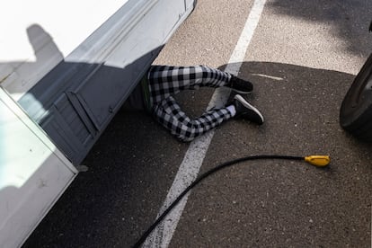Ayden connects a parking lot power cable to the motorhome.