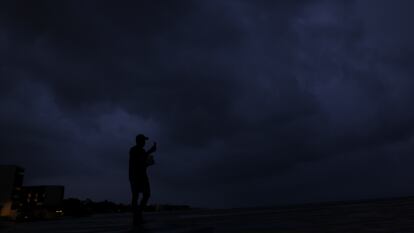 Una persona camina por la playa previo a la llegada del huracán 'Beryl', en Playa del Carmen, (México)