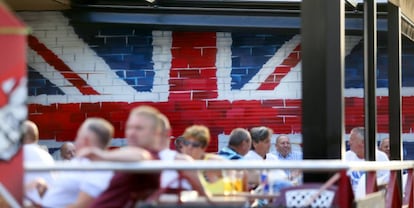 Turistas en una terraza en Benidorm, decorada con la bandera británica. 