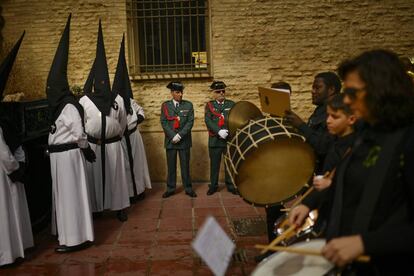 Agentes de la Guardia Civil, nazarenos y una banda de música participan durante la procesión de la hermandad de la Exaltación de La Santa Cruz, el 29 de marzo en Zaragoza.
