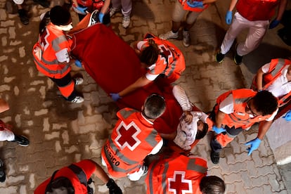 Personal sanitario de la Cruz Roja trasladan a un herido durante el sexto encierro. 