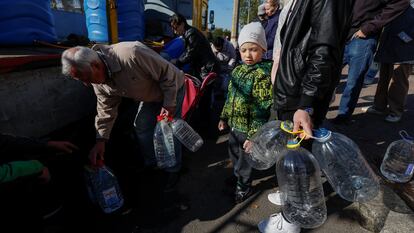 Ciudadanos en Jersón rellenan botellas de agua ante la falta del suministro, el 16 de octubre. 