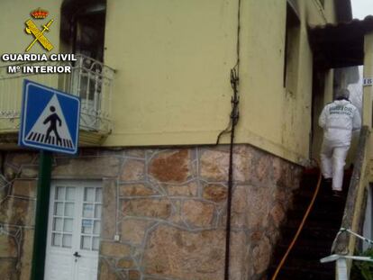 Un agente de la Guardia Civil en la casa incendiada en As Neves (Pontevedra).