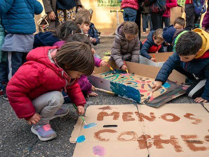 Alumnos y sus familias del colegio Menéndez Pelayo, de Madrid, preparan carteles para participar en la Revuelta Escolar contra los coches, este viernes.