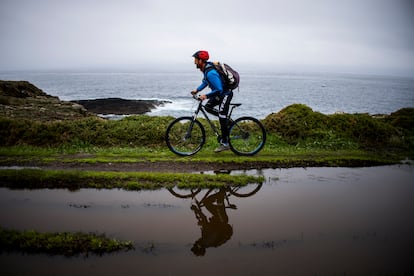 El guía Miguel Pérez recorre en bicicleta un tramo de la ruta en paralelo al mar desde el faro de Isla Pancha a la playa de las Catedrales.
