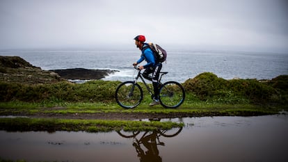 El guía Miguel Pérez recorre en bicicleta un tramo de la ruta en paralelo al mar desde el faro de Isla Pancha a la playa de las Catedrales.