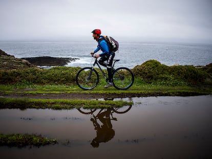 El guía Miguel Pérez recorre en bicicleta un tramo de la ruta en paralelo al mar desde el faro de Isla Pancha a la playa de las Catedrales.