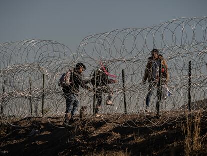 Tres migrantes cruzan el alambrado en la frontera entre México y EE UU en Ciudad Juárezm el pasado 10 de mayo.