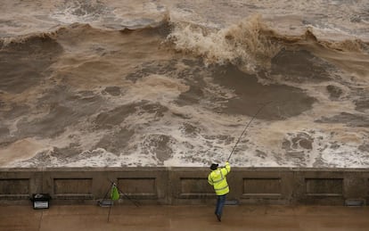 Un pescador lanza su caña durante el fuerte oleaje en Blackpool (Reino Unido).