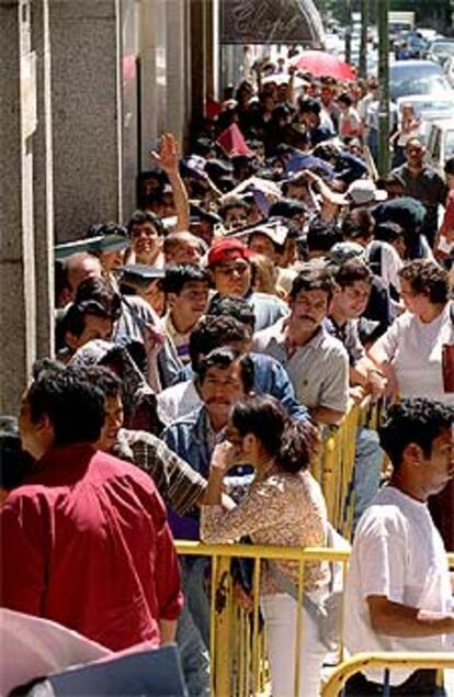 Colas de inmigrantes que buscan la regularización en Madrid.