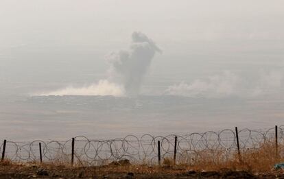 Foto tomada desde la cima del monte Zardak, a unos 25 kilómetros al este de Mosul, muestra una columna de humo saliendo de la ciudad iraquí de Ninive. 