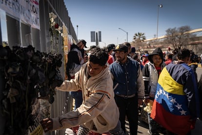 Migrantes colocan flores en el altar dedicado a 38 fallecidos durante el incendio de pasado lunes en el INM. 