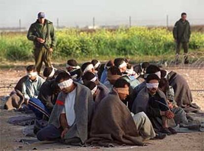 Soldados israelíes vigilan a varios detenidos palestinos en el campo de refugiados de Tulkarem, en Cisjordania.